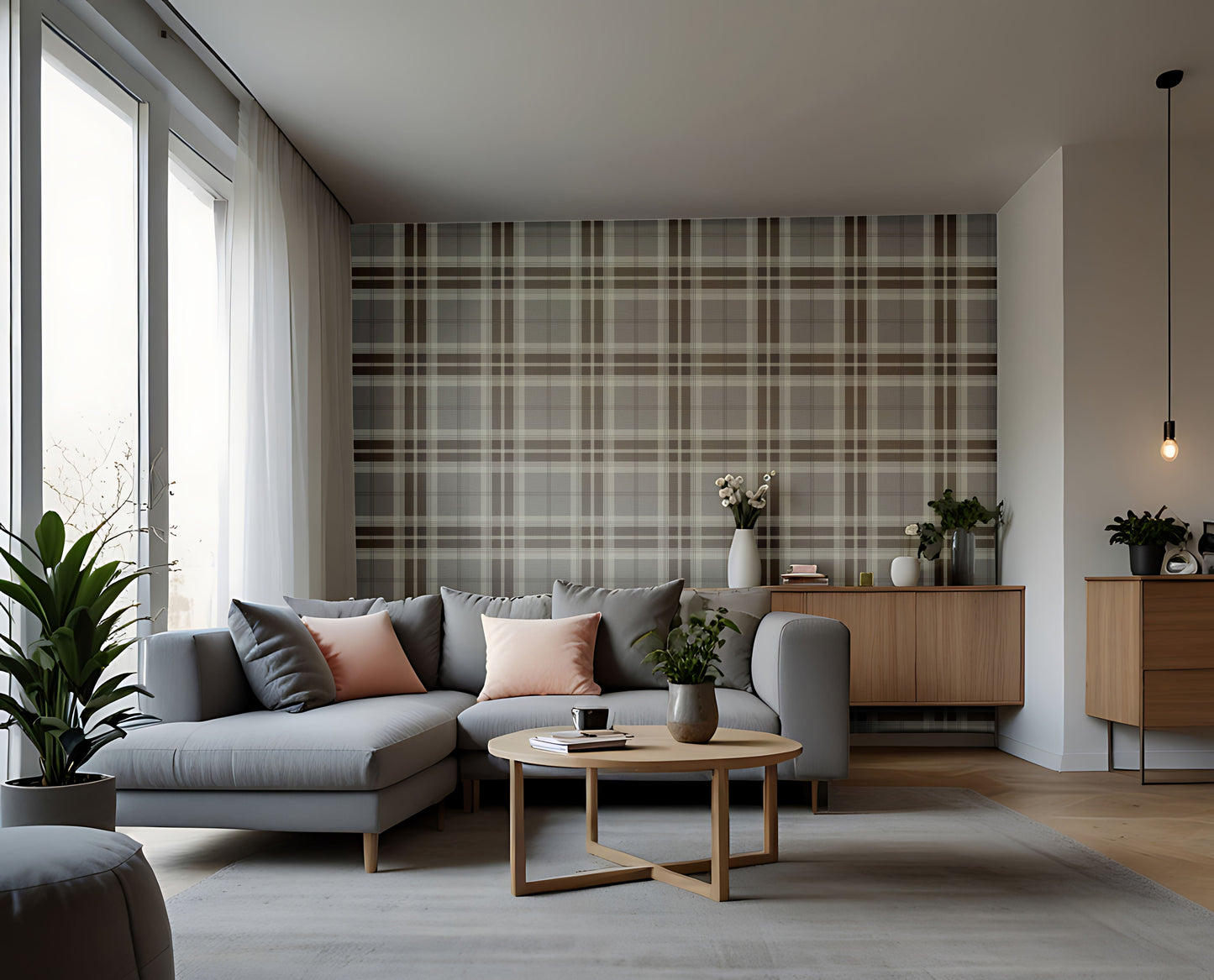 A modern entryway hallway features a classic truffle tartan plaid wallpaper in rich chocolate brown and cream tones.
The textured fabric-look design displays a bold grid pattern with intersecting brown and off-white bands.
In front, a minimalist light wooden console table stands next to a tall, dark wood interior door.
The warm, inviting space is completed by a round white globe lamp and a small decorative stool.