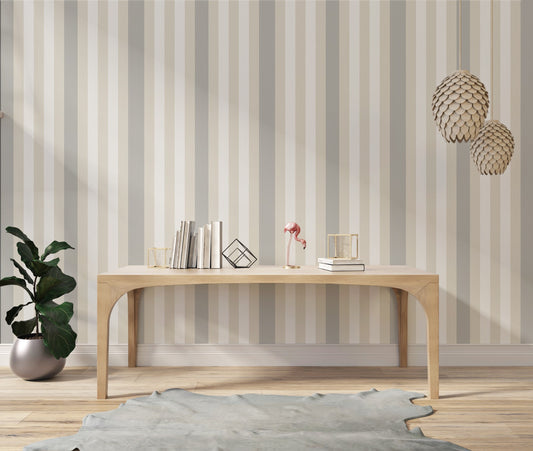 A modern living room features a textured striped wallpaper in a subtle sandstone theme.
The fabric-textured design shows clean vertical lines in light grey, cream, and warm beige.
In front, a minimalist light wooden console table sits straight in the center of the space.
The bright, open interior layout is beautifully completed by a green potted plant on the left.