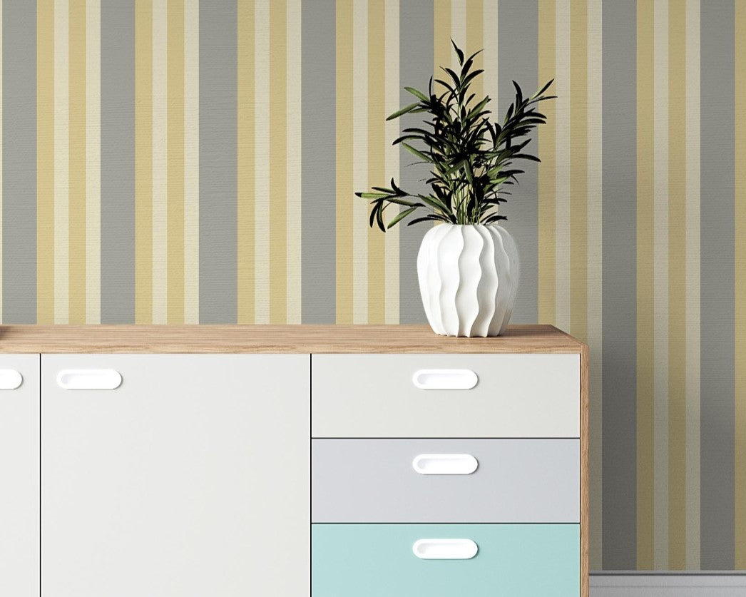 A contemporary room setup features a bold midnight timber wallpaper with vertical stripes.
The textured design displays alternating dark charcoal, brown, and grey vertical bands across the wall.
In front, a rustic wooden desk is paired with a matching wooden chair and a fabric armchair.
The sophisticated interior space is complete with a sleek black desk lamp and an open view window.