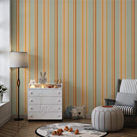 A child's playroom features a muted olive green wallpaper with warm colored stripes.
The detailed pattern shows vertical bands of orange, yellow, and cream running down the wall.
In front, a white giraffe-themed dresser stands next to a dark rocking chair and pouf.
The playful space is neatly arranged with children's toys and a round world map rug.