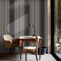 A moody room setup features a bold midnight timber charcoal and black striped wallpaper.
The detailed design shows alternating thick black vertical bands and dark grey patterned stripes.
In front, a rustic dark wood cabinet stands against the wall holding small decorative items.
The sophisticated interior setup is nicely finished with a minimalist black metal chair to the left.