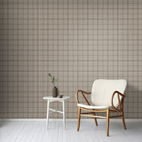 A minimal living room features a textured plaid wallpaper in desert dune tones.
The fabric-look pattern displays a structured grid with intersecting warm beige and soft tan lines.
In front, a comfortable light grey fabric sofa with a beige accent pillow is positioned on the right.
The clean interior setup is nicely completed by a dark grey wooden storage cabinet on the left.
