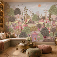 A cozy seating nook with a cushioned bench decorated with patterned pillows in beige, pink, and green. In front sits a small table holding two golden elephant figurines and a vase of white flowers. Behind, a large mural depicts a lush garden with domed pavilions, arches, flowering trees, and figures in traditional attire, creating an elegant and culturally inspired atmosphere.