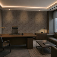 A sophisticated executive office with a warm, contemporary aesthetic: a large walnut desk, dark leather seating, integrated wood cabinetry, a textured taupe-gray feature wall, concealed warm LED lighting, recessed ceiling illumination, floor-to-ceiling windows with roller shades, and a refined lounge area with a leather sofa and marble coffee table. The palette is restrained and architectural, combining dark wood, charcoal, warm gray, and brass accents.
