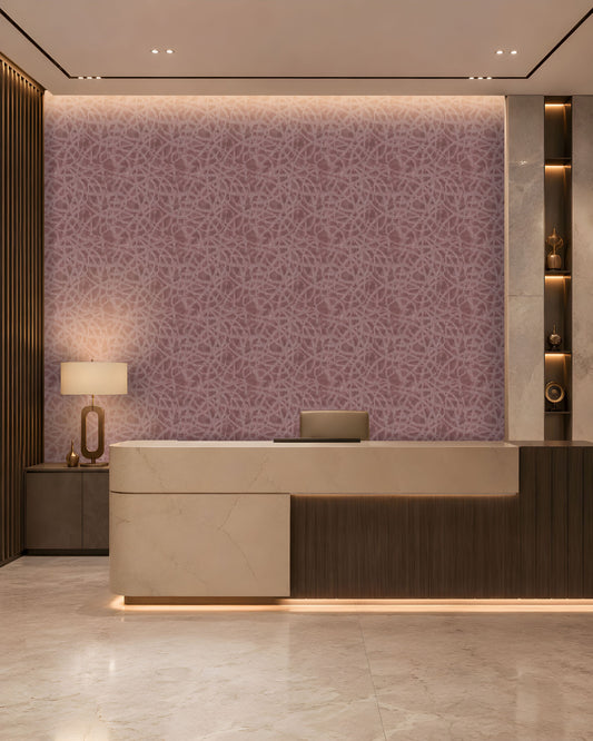 A refined contemporary reception area featuring a large curved-front desk in warm ivory stone and dark wood, with subtle integrated underlighting. The backdrop is a mauve-taupe textured feature wall with an intricate organic pattern and softly illuminated upper edge. Vertical dark-wood slats frame the left side, while marble-clad columns and illuminated display niches with sculptural décor frame the right. Warm architectural lighting, polished stone flooring, and restrained neutral tones create an elegant