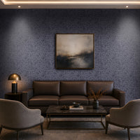 "Modern living room featuring a premium slate blue seamless texture wallpaper with an elegant organic abstract pattern that adds depth and visual interest to the walls. The sophisticated interior includes a dark brown leather sofa, two upholstered accent chairs, a black marble coffee table, warm brass table lamp, built-in wooden shelving with ambient lighting, abstract wall art, and floor-to-ceiling curtains. This luxurious textured wallpaper is ideal for contemporar