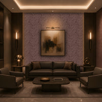 A luxurious contemporary lounge with a symmetrical layout, featuring a dark leather sofa and two matching armchairs around a low rounded rectangular marble coffee table. The room has a warm brown and taupe palette, dark wood built-in shelving, patterned textured wallpaper, brass-accented lighting, sculptural décor, and a large abstract artwork centered on the feature wall. Concealed cove lighting and warm wall sconces create an intimate, sophisticated atmosphere.
