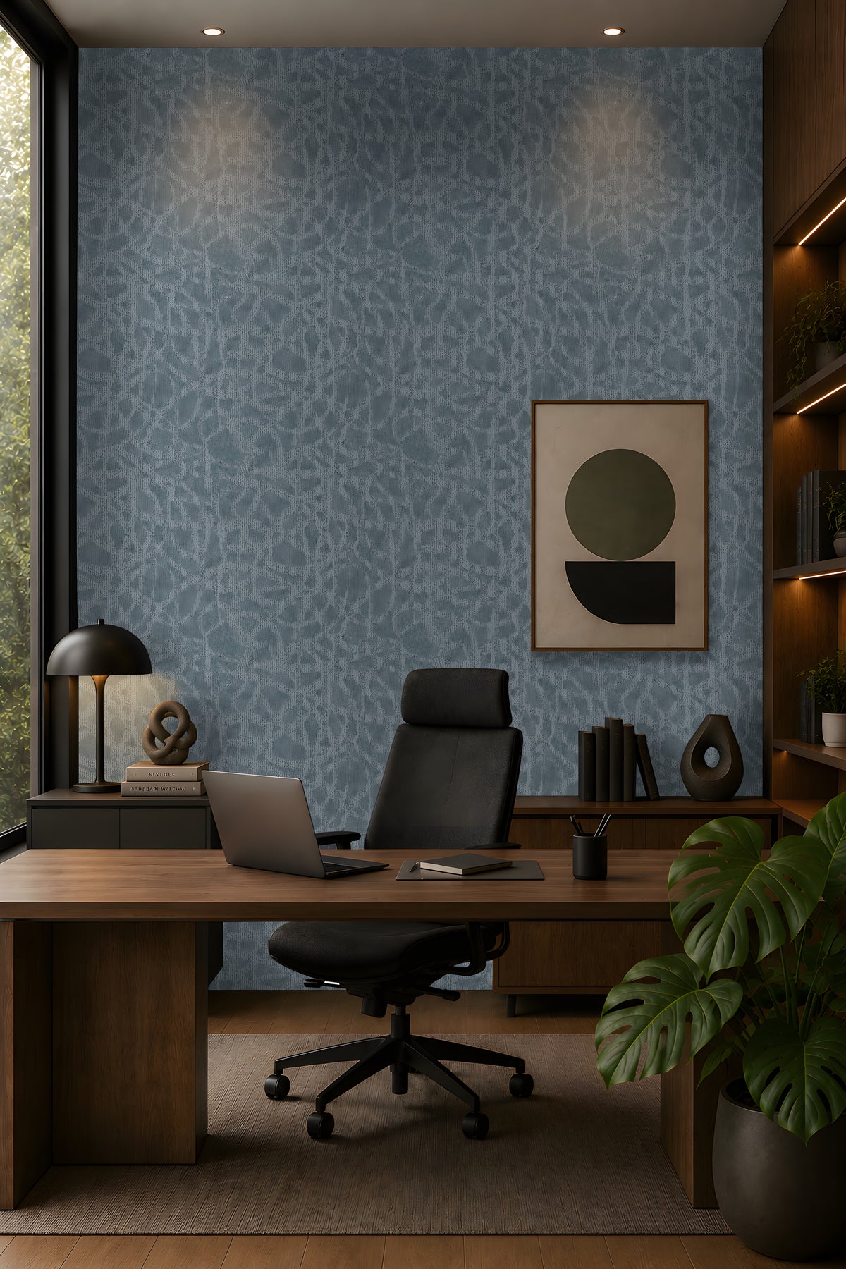 Modern luxury home office featuring dark blue textured wallpaper on the accent wall, a wooden executive desk, black office chair, abstract wall art, built-in wooden shelving, warm ambient lighting, and a large indoor tropical plant