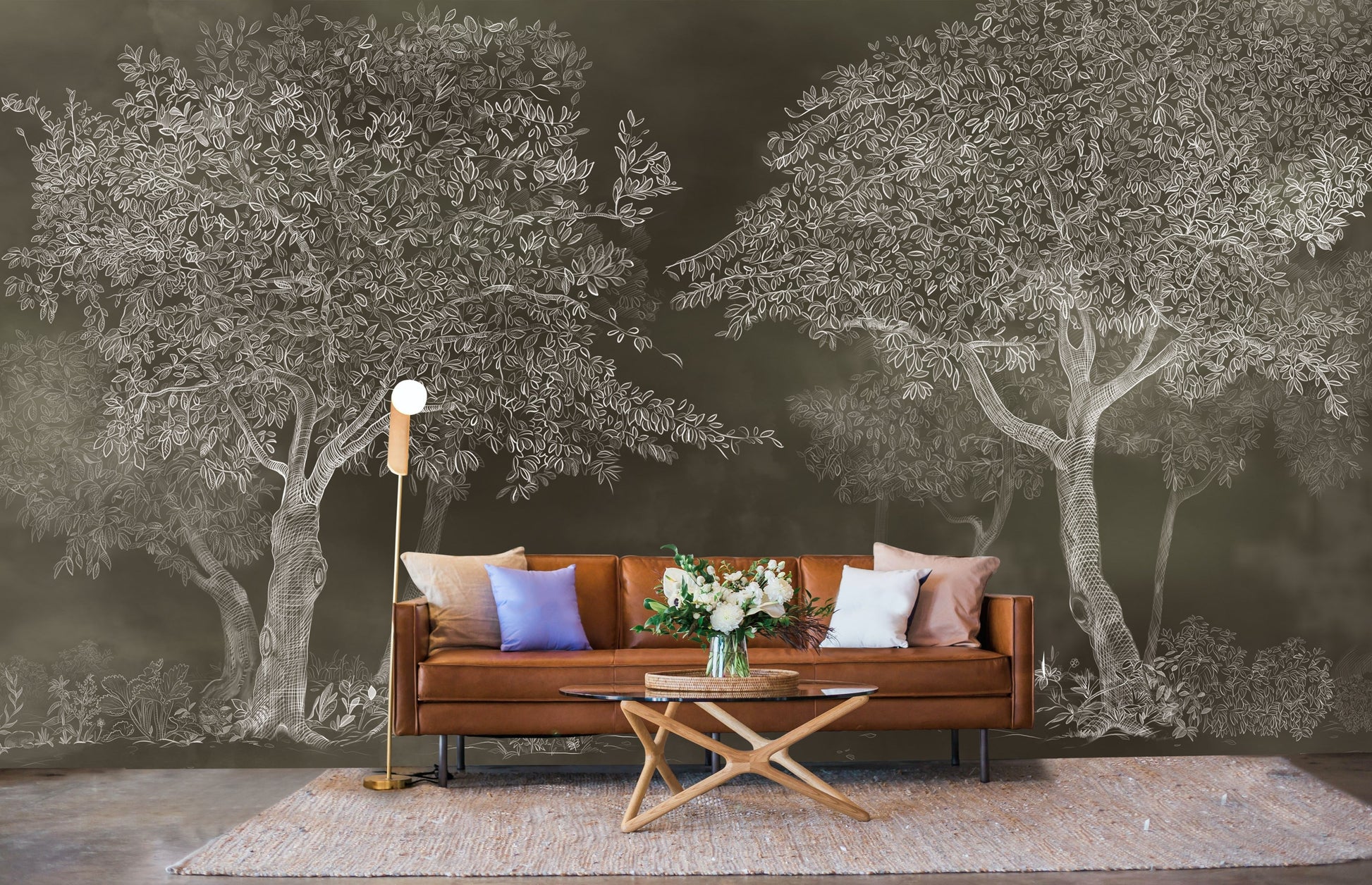 An architectural perspective of a sophisticated study featuring the Aranyam Dark Umber Mural as a full-scale feature wall behind a tan leather sofa. The mural’s dark, illustrative vista pairs elegantly with warm wooden furniture and gold accents, creating a moody and cultured interior sanctuary.