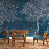 An architectural perspective of a sophisticated study featuring the Aranyam Mural in Rich Blue as a full-scale feature wall. The mural’s deep, illustrative vista pairs elegantly with crisp white trim and modern metallic accents, creating a moody and cultured interior sanctuary.