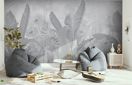 An architectural perspective of a contemporary living room featuring the Banana Grove Mural in Metal Gray as a full-scale feature wall behind a low-profile cream sofa. The mural’s desaturated botanical composition pairs elegantly with dark-toned furniture and minimalist accents, creating a peaceful and immersive urban sanctuary.