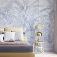 A high-resolution detail of the Banana Grove Dreams Blue Wallpaper, highlighting the delicate painterly textures and hand-painted veining of the tropical leaves. The image showcases the refined tonal transitions between deep teal, dusty blue, and soft ivory that define this nature-inspired mural.