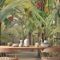 A high-resolution detail of the Banana Grove Dreams Yellow Wallpaper, showcasing the intricate painterly textures of the massive leaves and the detailed tropical blossoms. The image highlights the warm tonal variations of golden yellow, toasted amber, and soft cream that define this sun-drenched botanical mural.