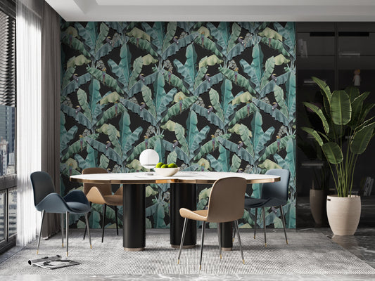 An architectural perspective of a contemporary lounge featuring the Banana Leaves Pattern as a full-scale feature wall. The wallpaper’s deep emerald and shadowy tones pair strikingly with a tan leather sectional, gold-toned lighting, and minimalist decor, creating a sophisticated and high-energy tropical atmosphere.