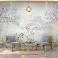 Elegant café seating area featuring Blossom Reverie ice blue floral landscape wallpaper with pink cherry blossom trees, misty forest scenery, and birds, complemented by blue upholstered chairs, wooden furniture, and soft lighting.