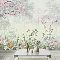Close-up of Blossom Reverie willow green floral landscape wallpaper featuring pink cherry blossoms, colorful wildflowers, delicate birds, and lush botanical foliage against a misty green forest background.