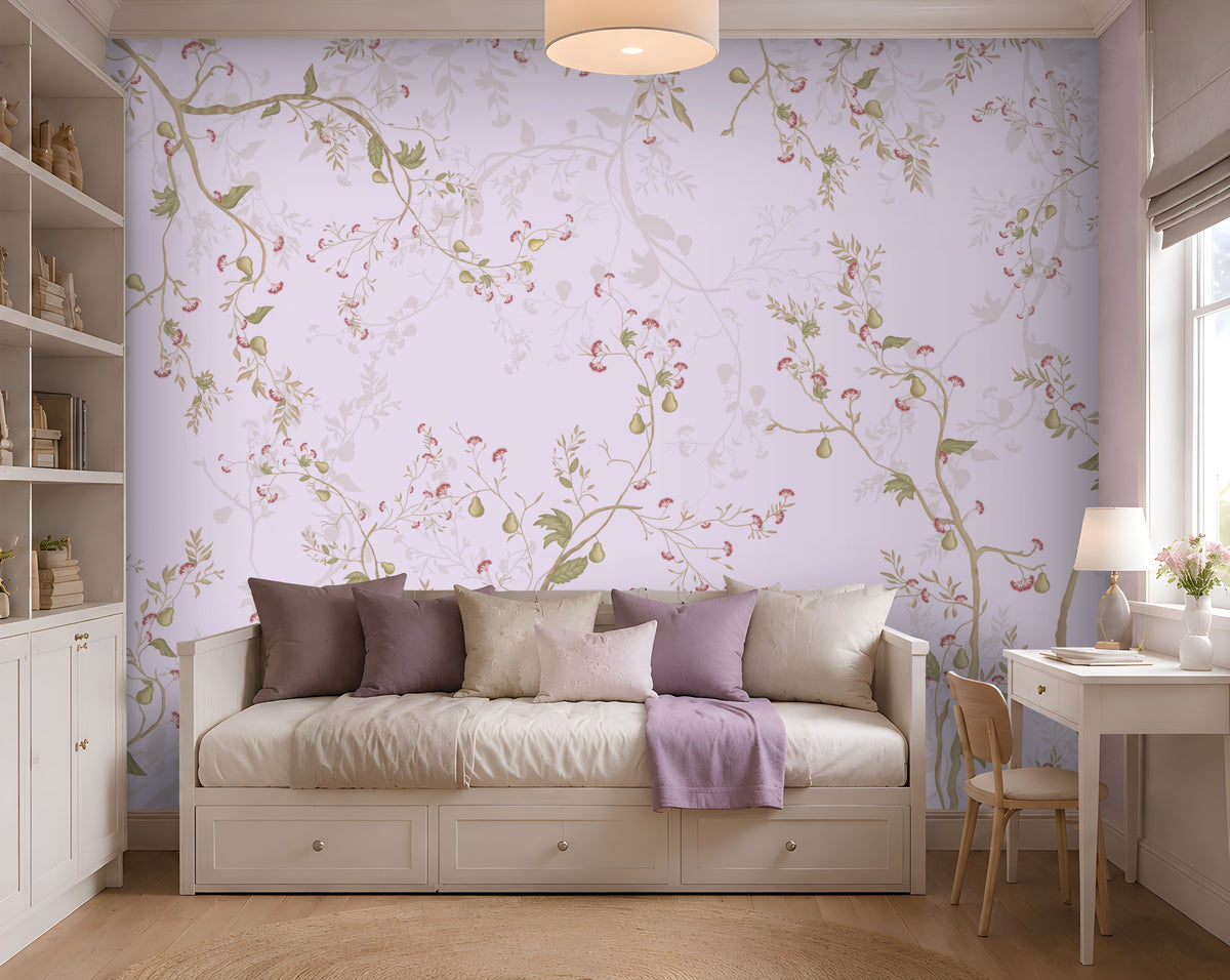 "A serene bedroom with a white daybed topped with purple and cream pillows and a lavender throw blanket. A floral pastel wallpaper covers the wall behind, featuring delicate vines in lavender, green, and pink. To the right, a white desk with a wooden chair, lamp, and vase of flowers sits near a window with Roman shades. Built-in shelves on the left display books and decorative items. Soft natural light and a ceiling lamp create a calm, elegant atmosphere."