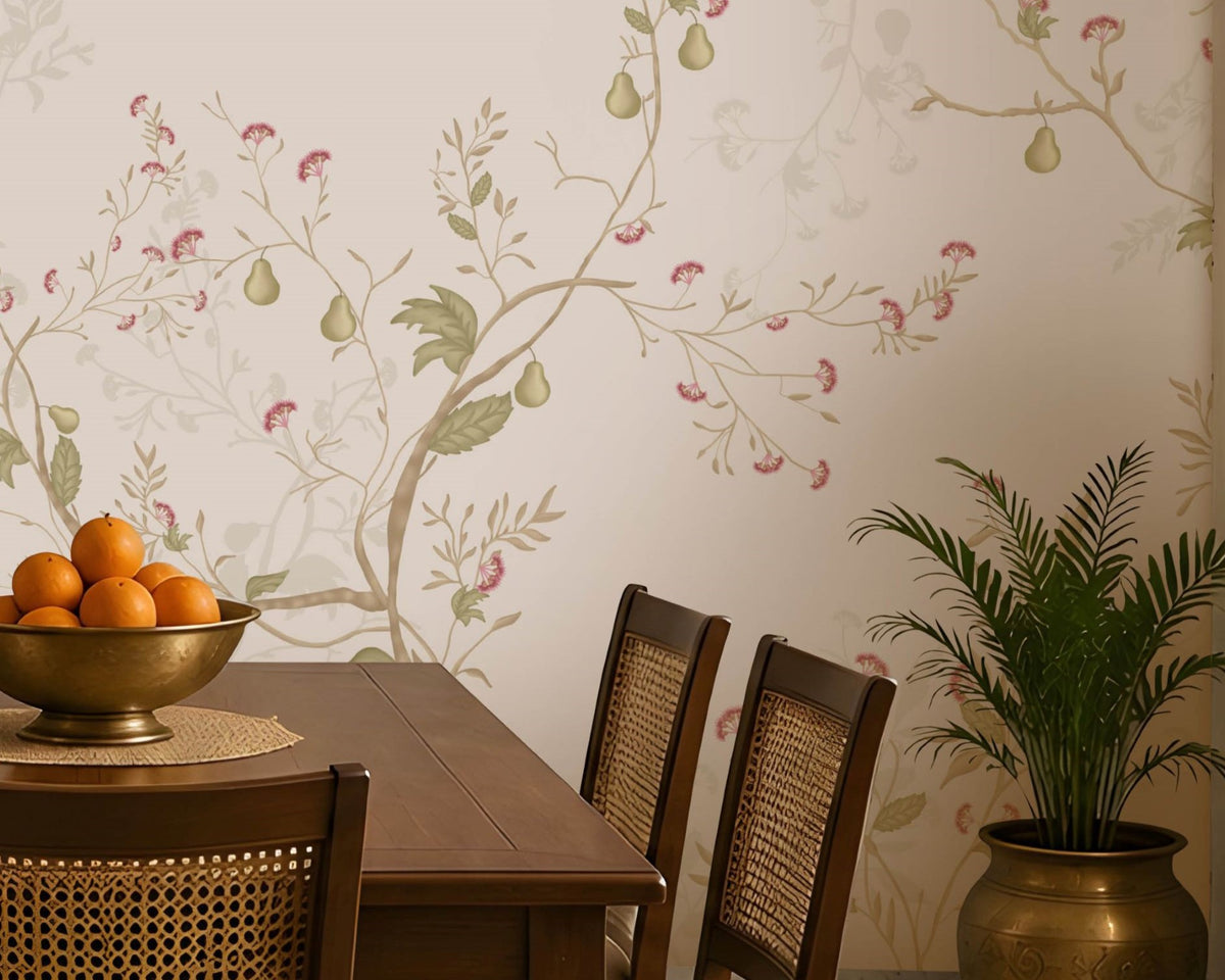 Blossom Veil Mural – Dusty Rose Pink floral wallpaper displayed across an elegant Indian-inspired dining room, featuring delicate pastel pink and peach blossoms intertwined with warm ivory vines, soft botanical branches, muted green leaves, and fine floral detailing on a subtle dusty rose pink background. The graceful floral composition flows seamlessly across the feature wall, creating a refined and sophisticated look. The room includes a traditional wooden dining table with woven 