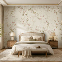 Sage cream floral wallpaper featuring delicate botanical branches and soft pink blossoms in an elegant, warm bedroom with neutral furnishings, wooden bedside tables, soft lighting, and a large upholstered bed.
