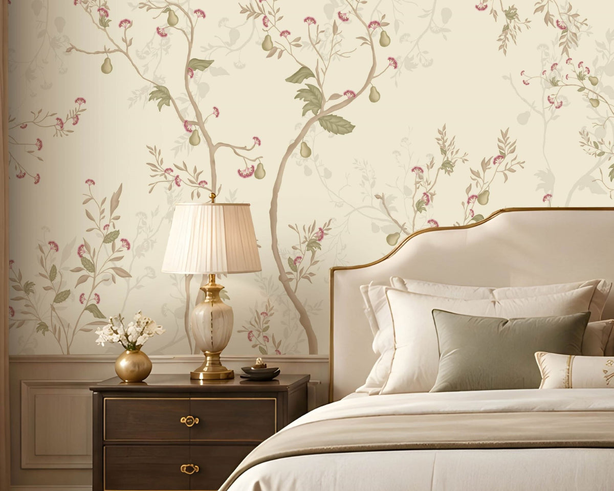 Warm ivory cream floral wallpaper with delicate botanical branches, soft pink flowers, muted sage green leaves, and subtle beige accents covering a large feature wall in an elegant luxury bedroom. The sophisticated room features a cream upholstered bed, neutral bedding, dark wooden bedside tables, classic lamps, a crystal chandelier, arched window with beige curtains, plush seating, decorative furniture, and a warm refined interior that complements the wallpaper’s soft botanical design.
