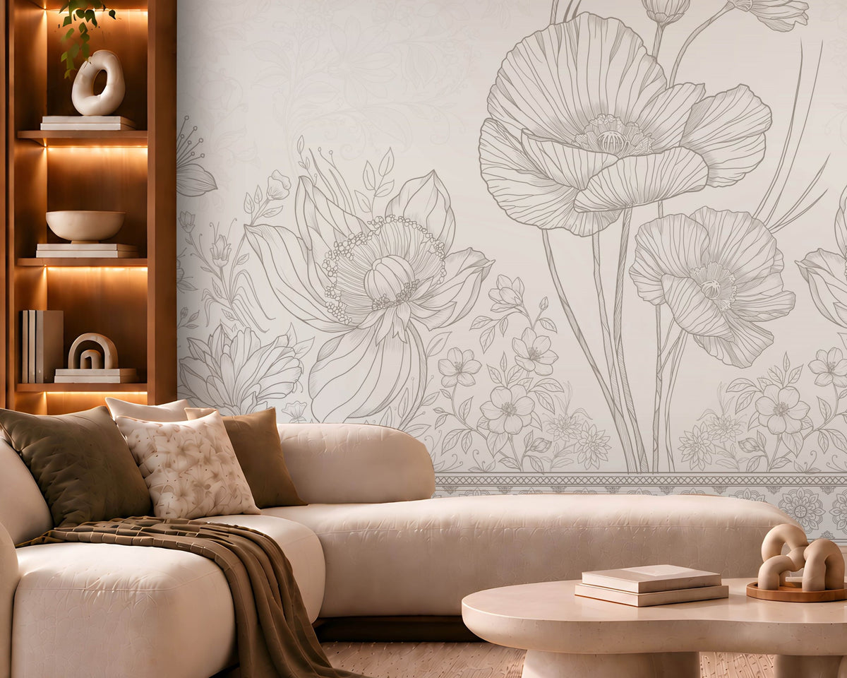 A modern living room featuring a large wall mural with delicate gray floral line art on a light beige background. The room is styled with a cream-colored sectional sofa, a round stone coffee table, a wooden armchair, and warm ambient lighting.