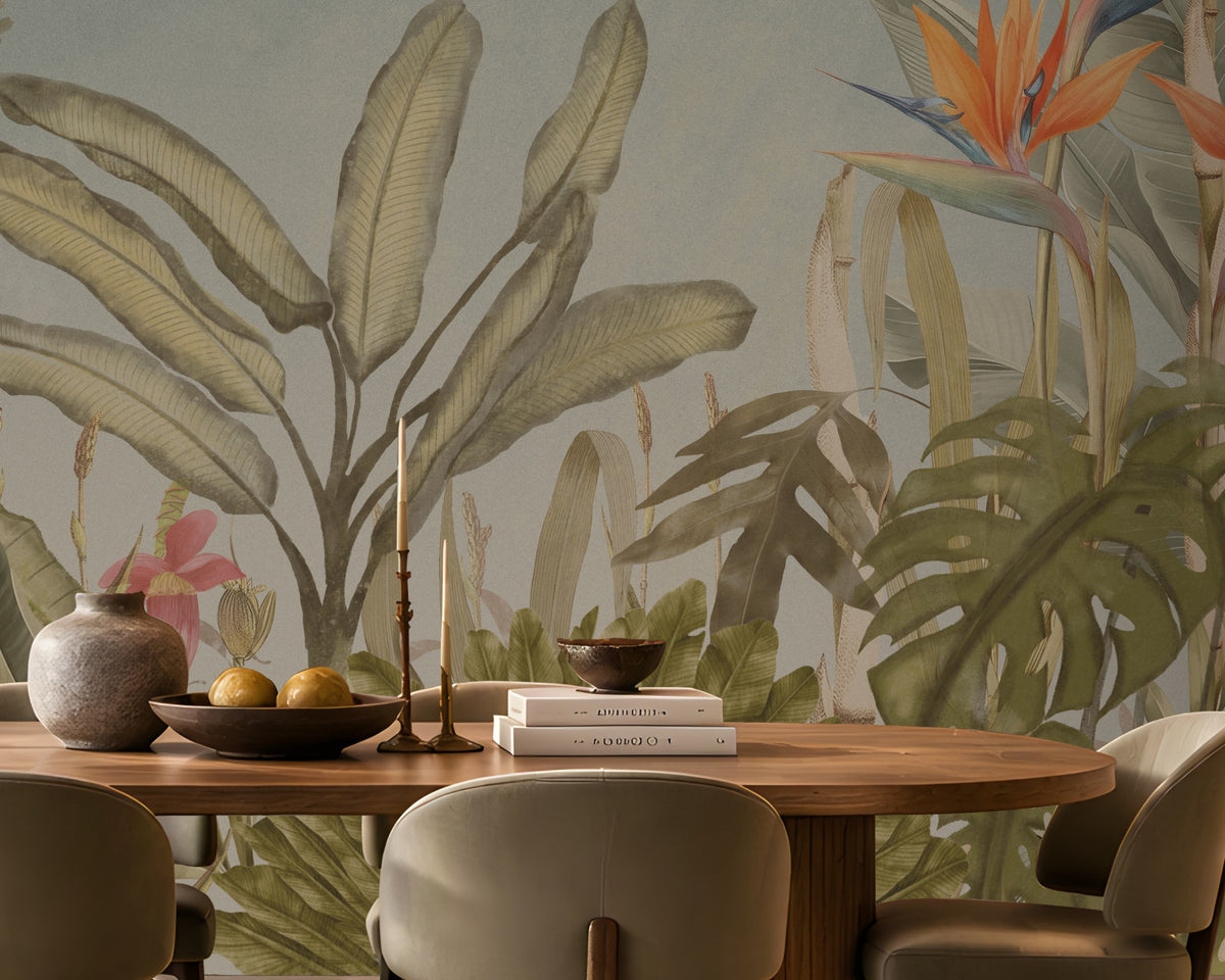 Earthy Tropical Oasis - Dusty Blue botanical wallpaper featuring lush tropical foliage, oversized bird-of-paradise flowers in warm orange, coral, and muted blue tones, and layered olive green leaves against a soft dusty blue background. Showcased in an elegant dining room with a natural wooden dining table, upholstered chairs in earthy neutral shades, warm pendant lighting, and textured décor, this tropical wallpaper brings a calming, nature-inspired charm and sophisticated elegance to contemporar