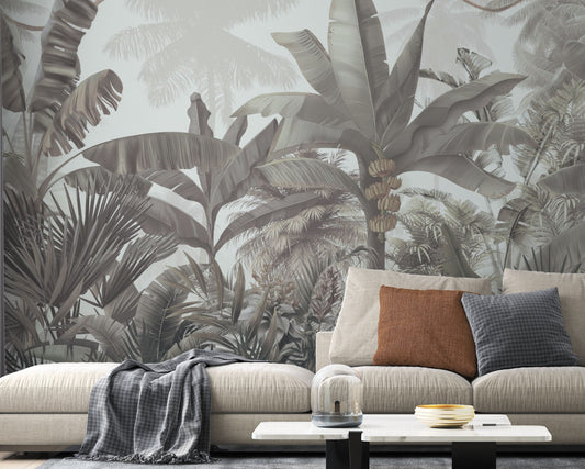 A high-resolution detail of the Enchanted Tropics Soft Grey Wallpaper, showcasing the intricate illustrative linework of the banana fruit clusters and the layered, semi-translucent textures of the large tropical leaves. The image highlights the refined tonal transitions between smoky charcoal, misty grey, and soft ivory that define this nature-inspired mural.
