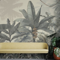 A high-resolution detail of the Enchanted Tropics Tropical Wallpaper, showcasing the intricate, illustrative linework of the banana fruit clusters and the fine textures of the towering palm fronds. The image highlights the gentle tonal transitions between warm beige, muted olive, and soft slate grey that define this exotic jungle mural.