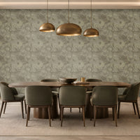 A spacious modern dining room featuring a large accent wall decorated with seamless floral swirl wallpaper in muted olive grey, soft sage, and warm taupe tones. The intricate repeating floral pattern adds depth, texture, and understated elegance to the interior. A rich dark wooden dining table paired with plush olive grey upholstered chairs complements the wallpaper beautifully, while elegant brass pendant lights, warm wooden cabinetry, and soft ambient lighting create a sophisticated atmosphere.