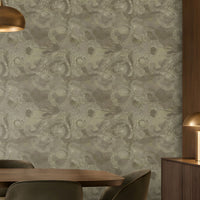 A spacious modern dining room featuring a large accent wall decorated with seamless floral swirl wallpaper in muted olive grey, soft sage, and warm taupe tones. The intricate repeating floral pattern adds depth, texture, and understated elegance to the interior. A rich dark wooden dining table paired with plush olive grey upholstered chairs complements the wallpaper beautifully, while elegant brass pendant lights, warm wooden cabinetry, and soft ambient lighting create a sophisticated atmosphere.