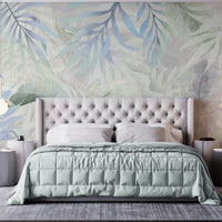 Muted gray colour Exotica Blend tropical leaf mural wallpaper displayed as a feature wall in a living room, dining room, and bedroom, highlighting neutral gray tones and modern tropical mural wallpaper design.