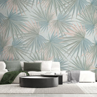 An architectural perspective of a contemporary minimalist lounge featuring the Fan Palm Leaves Mural in Pastel Grey Green as full-scale feature wall. The mural’s soft, oversized botanical patterns pair elegantly with charcoal metal accents and light wood flooring, creating a serene and cultured interior sanctuary.