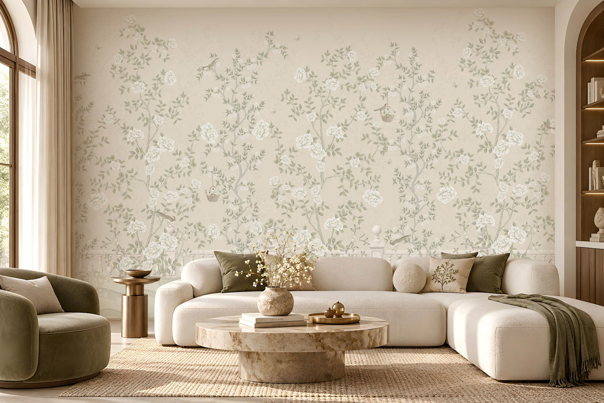 Luxury living room featuring Florentine Bloom soft beige floral wallpaper with white roses and botanical vines, complemented by a cream sofa, wooden furniture, and natural window lighting.