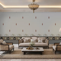 Elegant Indian living room featuring a Pichwai motif seamless wallpaper with soft grey chevron patterns, delicate red paisley accents, and traditional cow illustrations along a decorative border. The space is styled with neutral-toned premium furniture, cane armchairs, a classic sofa, brass lighting, and a marble center table, creating a soothing, luxurious Hyderabad-inspired ambience with the wallpaper clearly visible as the focal point.