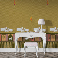 A high-resolution detail of the Heritage Pichwai Seamless Wallpaper, showcasing the intricate repeat pattern of stylized cypress trees and the ornate lower border. The design highlights traditional Pichwai motifs, including sacred cows and palms in decorative arches, rendered in vibrant mustard and ochre tones against a mustard ocher chevron-textured background.
