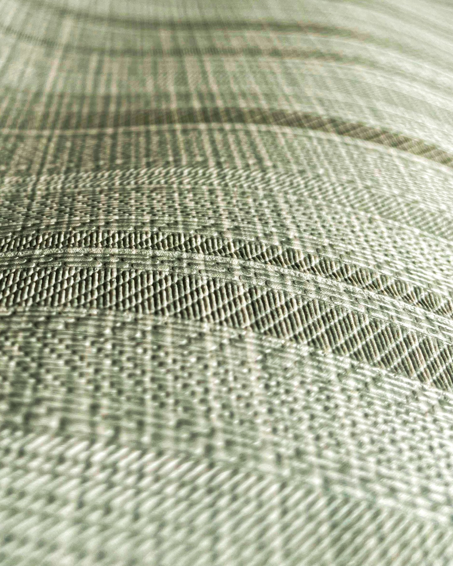 A high-resolution macro detail of Sage Waterproof Wallcovering, showcasing a unique hybrid herringbone and basket-weave emboss. The image captures rhythmic, arched bands of dense textile texture, revealing a high-tactile, light-diffusing surface designed for industrial-grade durability.