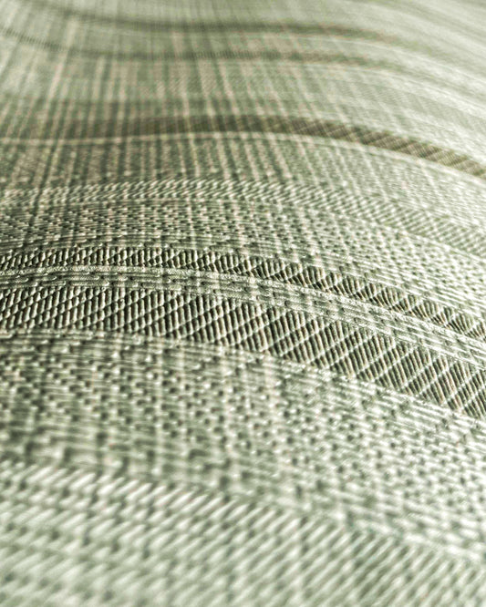 A high-resolution macro detail of Sage Waterproof Wallcovering, showcasing a unique hybrid herringbone and basket-weave emboss. The image captures rhythmic, arched bands of dense textile texture, revealing a high-tactile, light-diffusing surface designed for industrial-grade durability.