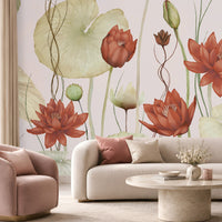 A large-scale wall mural featuring watercolor-style red lotus flowers and green lily pads, shown in a modern living room setting behind a cream sofa, a pink armchair, and a round coffee table.