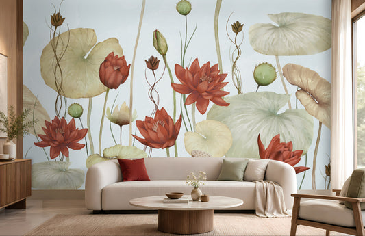 A large-scale wall mural featuring watercolor-style red lotus flowers and beige lotus lily pads on a pale blue background, shown installed in a modern living room setting behind a cream sofa and round coffee table.