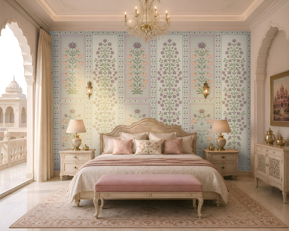 Luxurious heritage-style bedroom featuring pastel purple, dusty pink, and muted sage green floral wallpaper with intricate botanical motifs and decorative panel borders on a soft ivory background. The elegant wallpaper complements a cream upholstered bed with a carved cane headboard, blush pink cushions and bedding, a matching pink upholstered bench, and ornate ivory bedside tables.