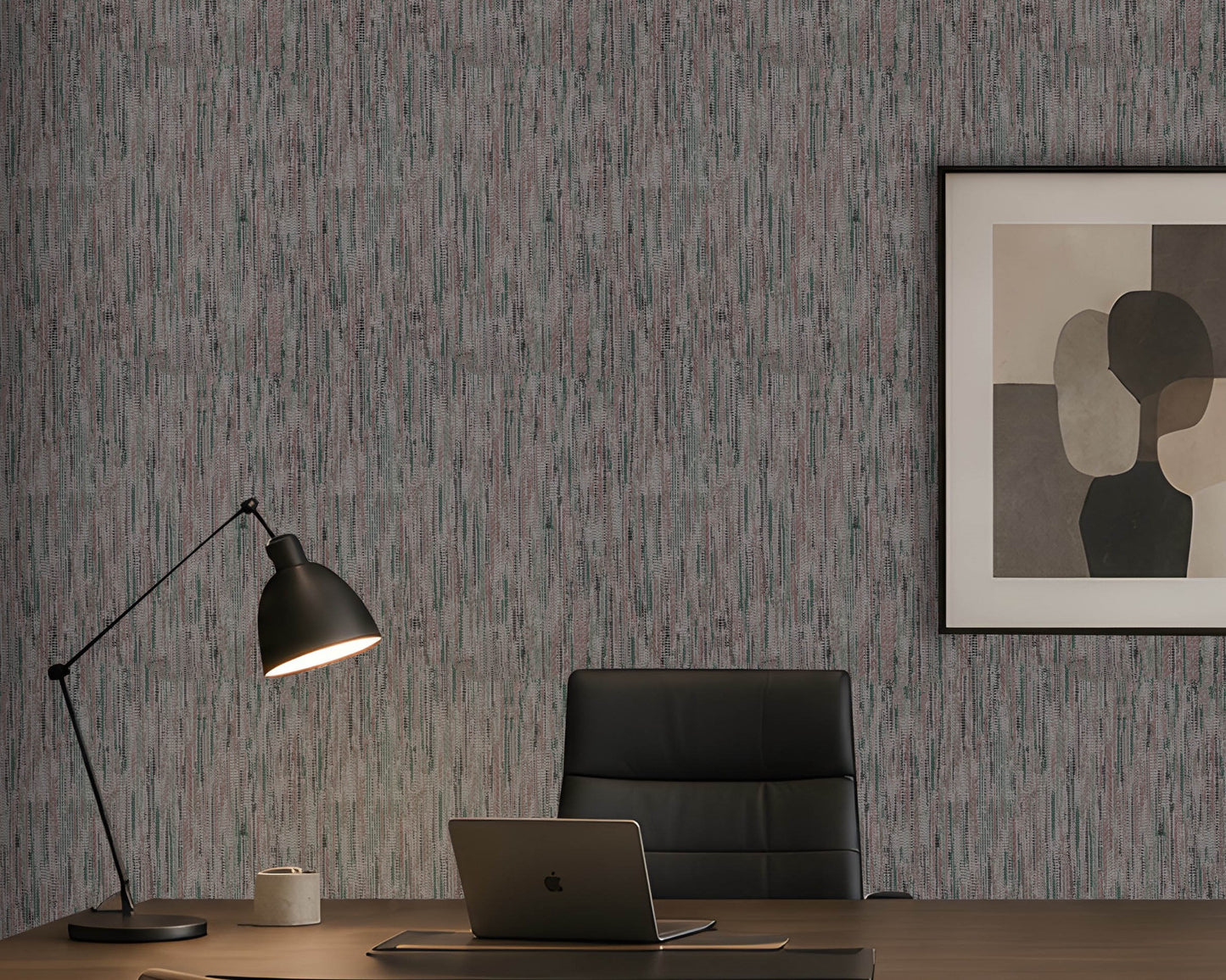 A styled home office scene featuring textured vertical wood-look wallpaper in gray and muted blue tones, a black desk lamp, a black leather office chair, a laptop on a wooden desk, and a framed abstract art print on the wall.