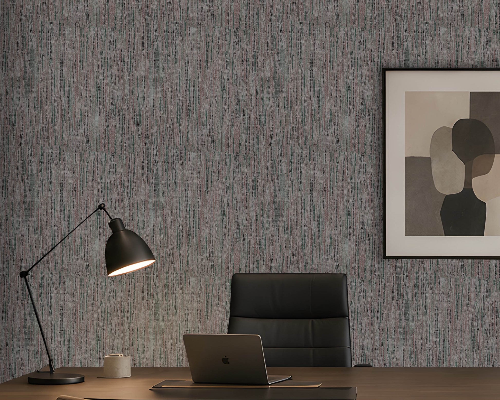 A styled home office scene featuring textured vertical wood-look wallpaper in gray and muted blue tones, a black desk lamp, a black leather office chair, a laptop on a wooden desk, and a framed abstract art print on the wall.