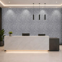 A modern reception desk in a sleek office lobby, featuring a white marble front with a dark wood side panel and a textured gray accent wall behind it.
