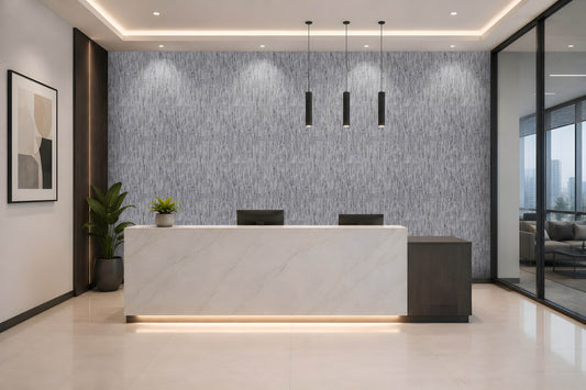 A modern reception desk in a sleek office lobby, featuring a white marble front with a dark wood side panel and a textured gray accent wall behind it.