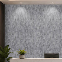 A modern interior scene featuring a textured gray and white vertical brushstroke wallpaper on the back wall, with a white reception desk, a small potted plant, a computer monitor, and a dark wood slatted accent wall on the left.