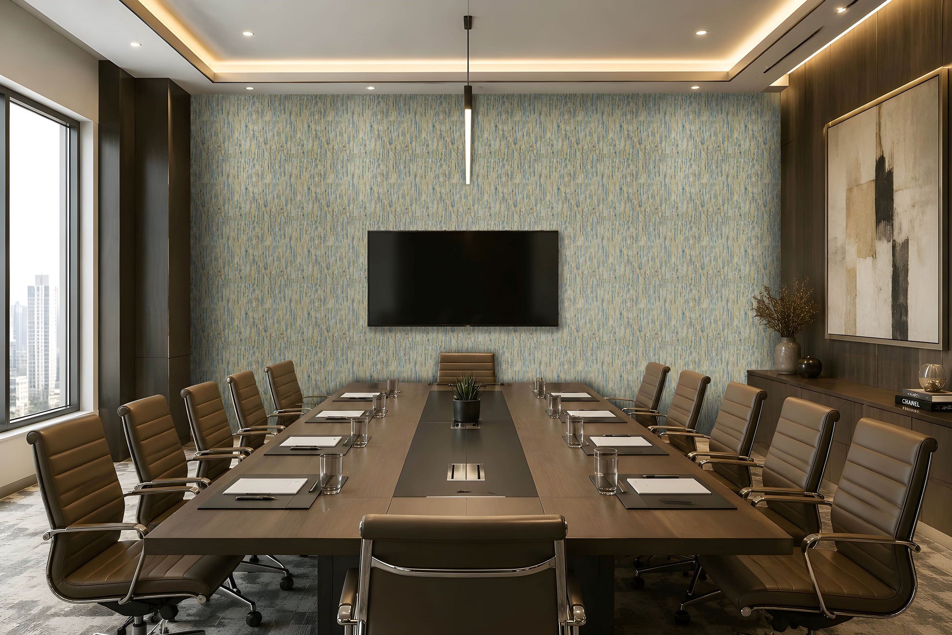 A modern conference room with a long rectangular wooden table, multiple brown office chairs, a large wall-mounted TV, patterned blue-gray wallpaper, recessed ceiling lighting, and a large framed abstract artwork on the right wall.