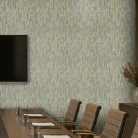 A modern conference room featuring a wall covered in vertical textured wallpaper with a blue and beige brushstroke pattern. A long wooden conference table, beige leather chairs, a wall-mounted flat-screen TV, and a sideboard with a vase of branches are visible.