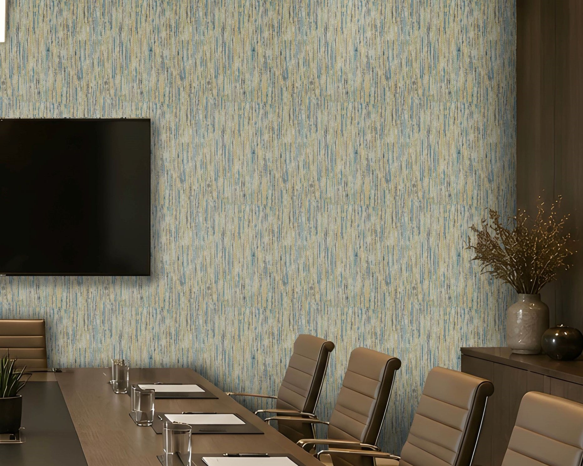 A modern conference room featuring a wall covered in vertical textured wallpaper with a blue and beige brushstroke pattern. A long wooden conference table, beige leather chairs, a wall-mounted flat-screen TV, and a sideboard with a vase of branches are visible.