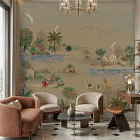 Beige-toned living room featuring a large mural-style wall with a serene landscape of trees, birds, and figures in soft muted colors. In front of the wall are three upholstered chairs—two cream and one rust-colored—arranged around a small round coffee table on a patterned marble floor. A glass chandelier hangs from the ceiling, and a wooden desk with decorative items sits to the right. Natural light enters from a large window on the left, enhancing the warm, neutral palette.