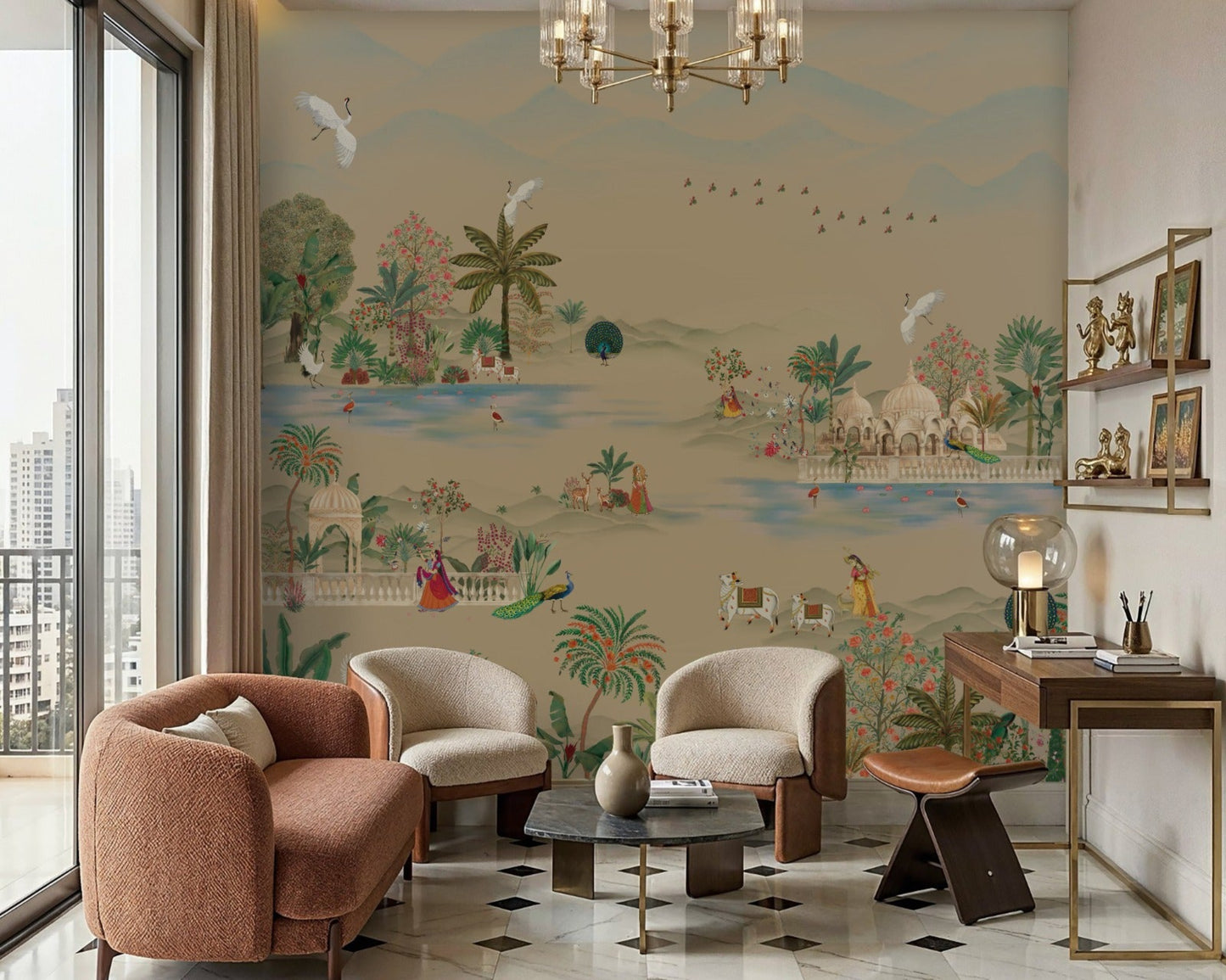 Beige-toned living room featuring a large mural-style wall with a serene landscape of trees, birds, and figures in soft muted colors. In front of the wall are three upholstered chairs—two cream and one rust-colored—arranged around a small round coffee table on a patterned marble floor. A glass chandelier hangs from the ceiling, and a wooden desk with decorative items sits to the right. Natural light enters from a large window on the left, enhancing the warm, neutral palette.